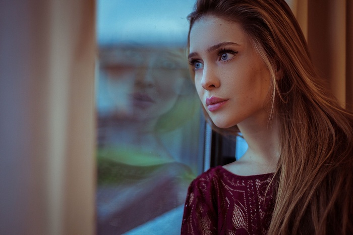 Woman with blue eyes looking out a window