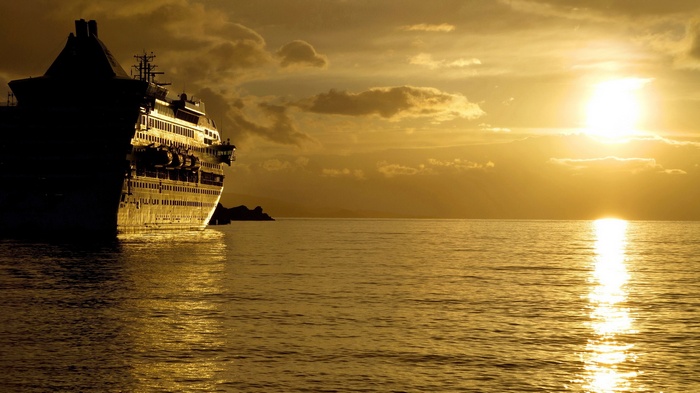 Cruise ship sailing at sunset