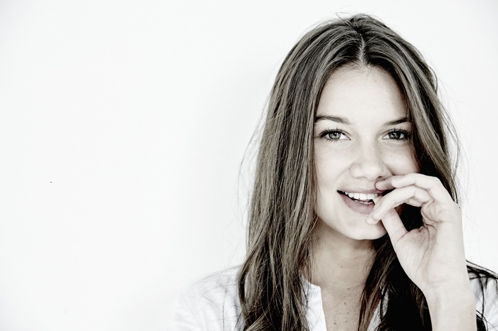 Model Hailey Outland smiles with her hand near her mouth