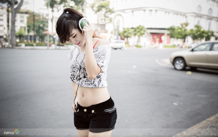 Asian woman with headphones listening to music outdoors