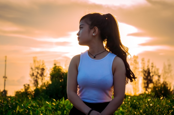 Asian woman with ponytail at sunset