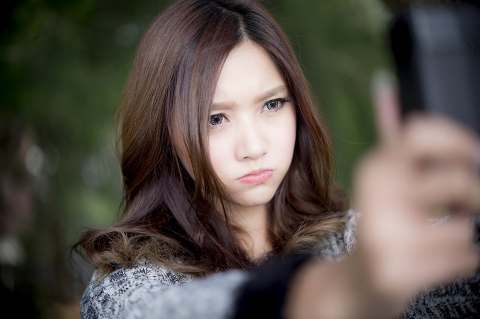 Asian woman taking a selfie with a pout