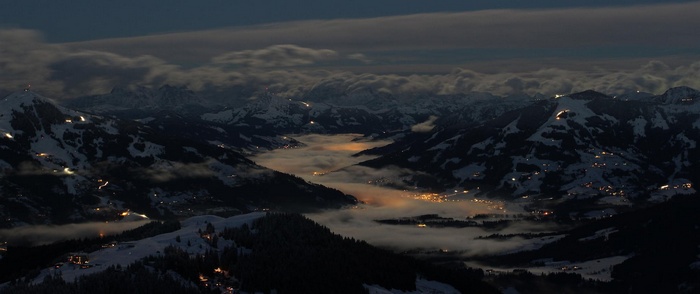 Town in a misty mountain valley at night