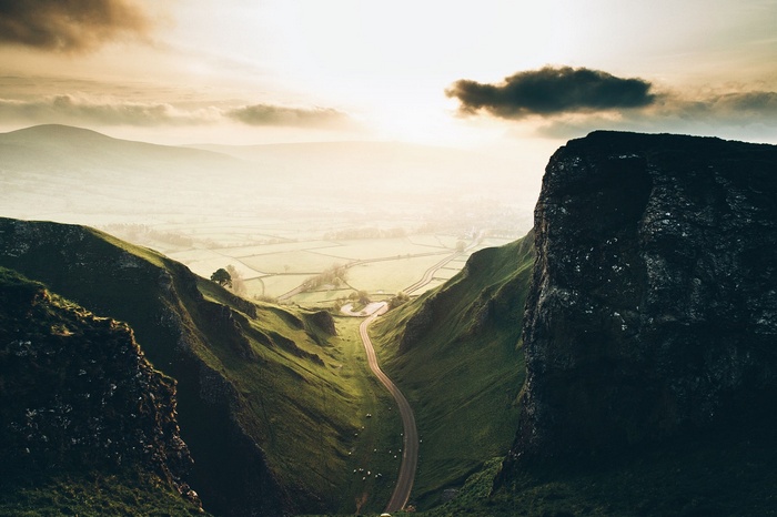 Scenic mountain valley with a winding road at sunset