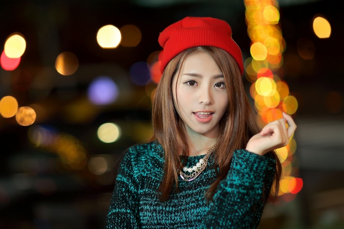 Asian woman wearing a red hat and necklace