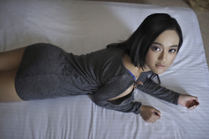 Asian woman lying on a bed
