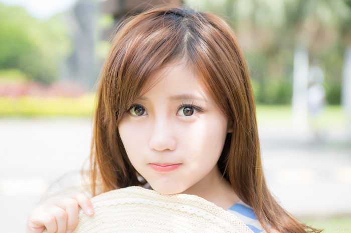 Gao Minmin poses with a straw hat outdoors