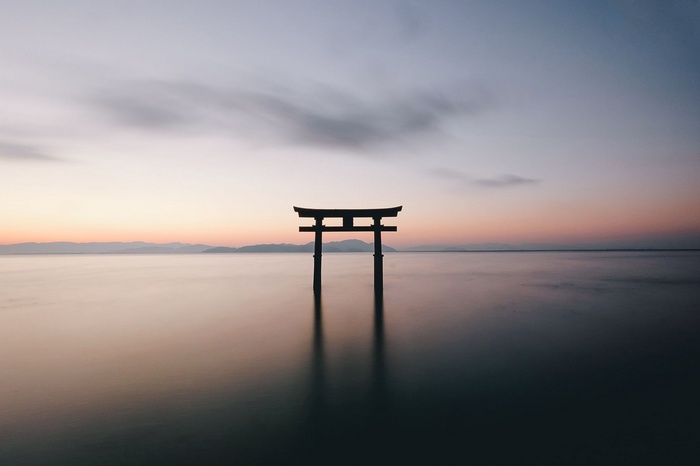 Torii gate in the water at sunset