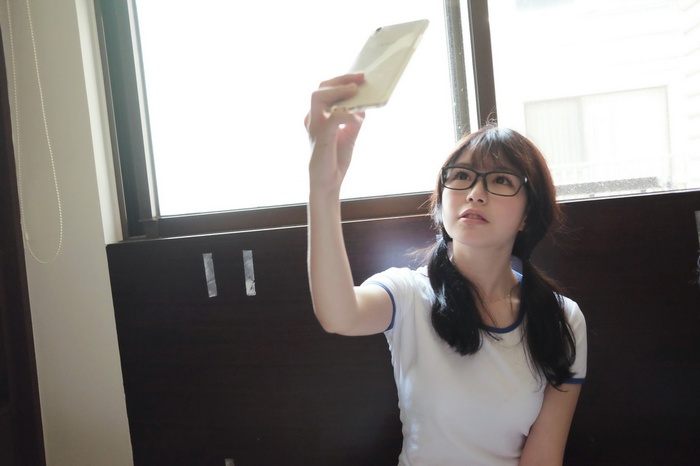Asian girl taking a selfie by the window