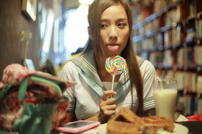 Asian woman with lollipop and waffles