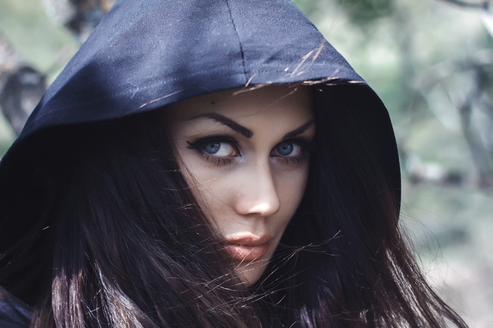 Woman with long dark hair and blue eyes wearing a hood