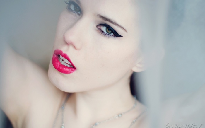 Woman with bright red lipstick and winged eyeliner