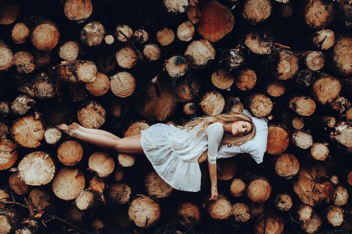 Woman sleeping on a pillow on a pile of logs