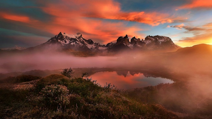 Torres del Paine mountains at sunset with mist and lake reflection