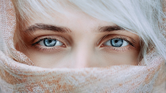 Close-up of a woman's blue eyes and white hair