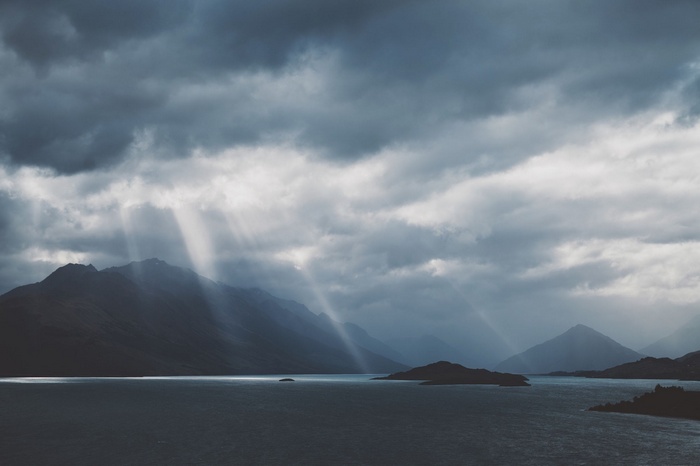 Sun rays over mountains and a lake