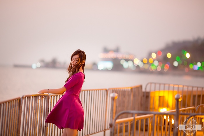 Asian woman in a pink dress by the water