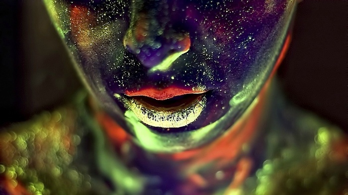 Close-up of a face with colorful paint and glitter