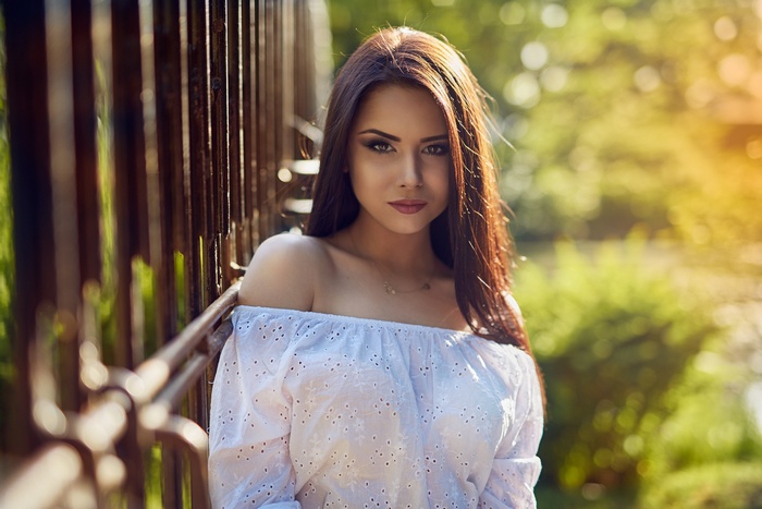 Woman with long brown hair and white top
