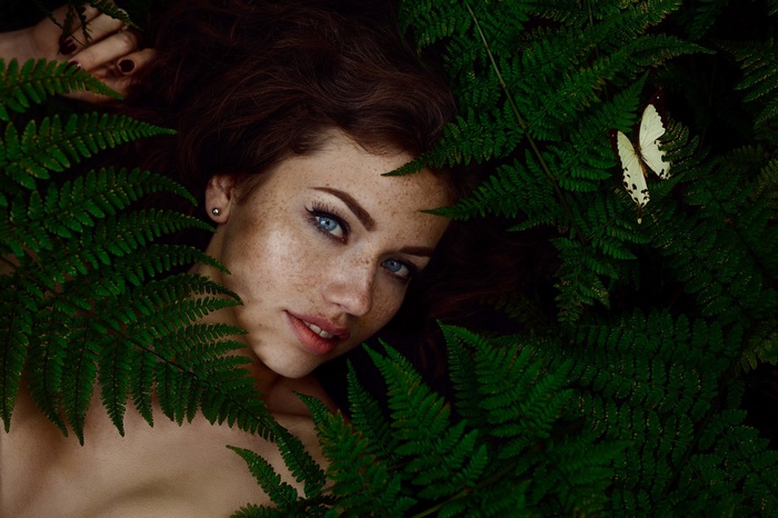 Svetlana Grabenko with blue eyes and freckles among ferns