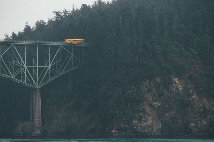 Yellow school bus on a bridge over water