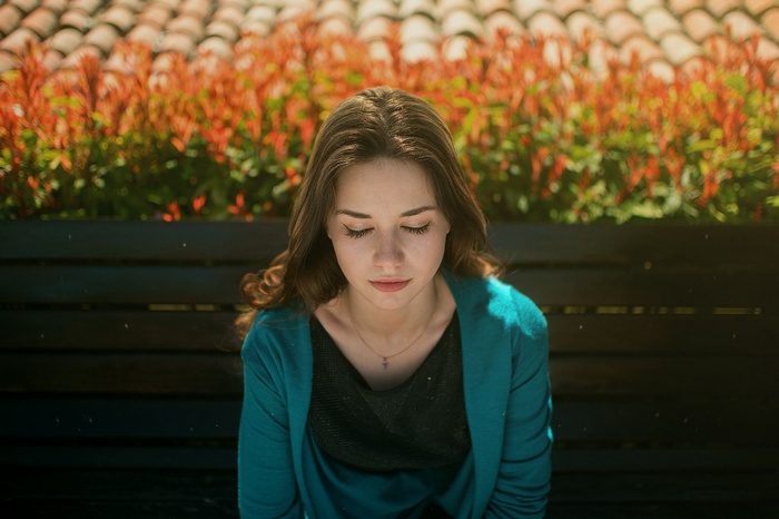 Radina sitting on a bench with eyes closed