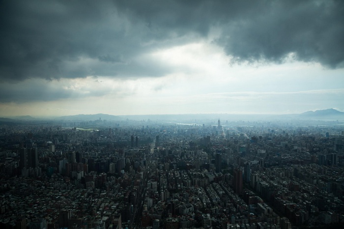 Aerial view of a sprawling city under stormy clouds