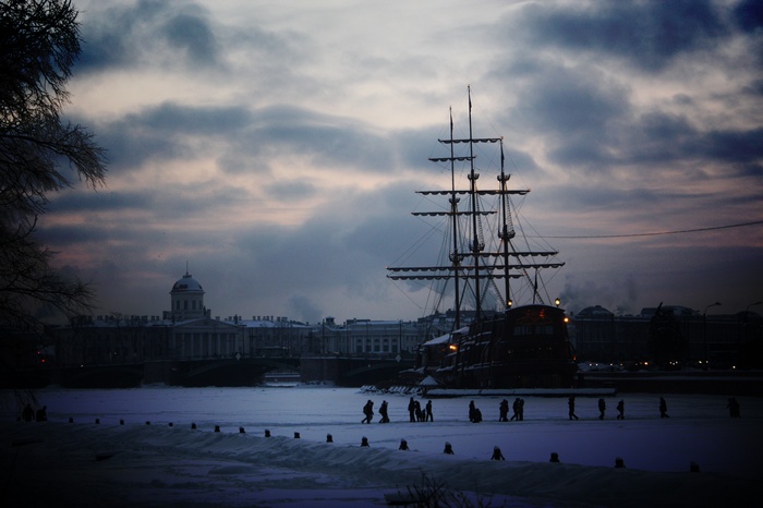 Sailing ship on a frozen river in St. Petersburg at dusk