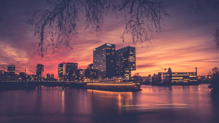 Cityscape with modern buildings at sunset over water