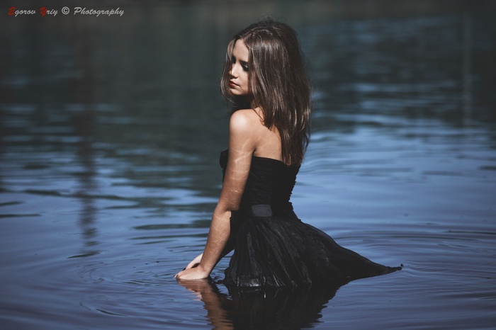 Ksenia Kokoreva in a black dress in a lake
