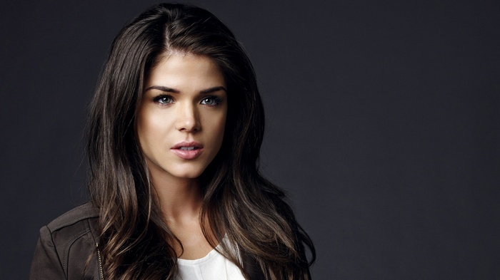 Marie Avgeropoulos with long brown hair and gray eyes
