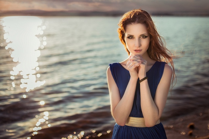 Woman in a blue dress by the sea