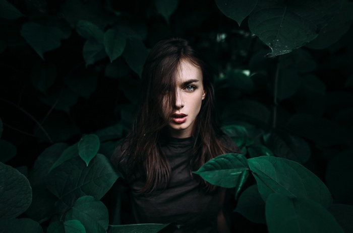 Viktoria Vishnevetskaya surrounded by dark green leaves