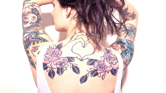 Woman with heart and rose tattoos on her back