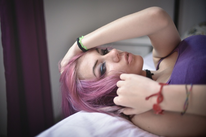 Woman with pink dyed hair lying down