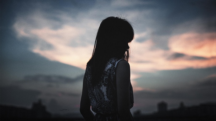 Silhouette of a woman with dark hair at sunset