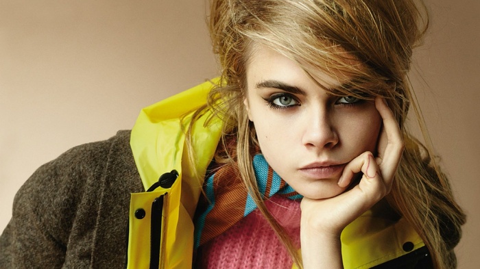Cara Delevingne wearing a yellow jacket and grey coat