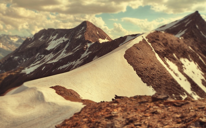 Snowy mountain range under a cloudy sky