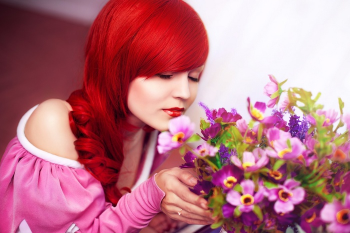 Redhead woman smelling a bouquet of flowers