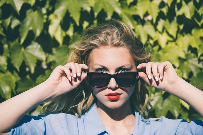 Woman with blonde hair wearing sunglasses and red lipstick