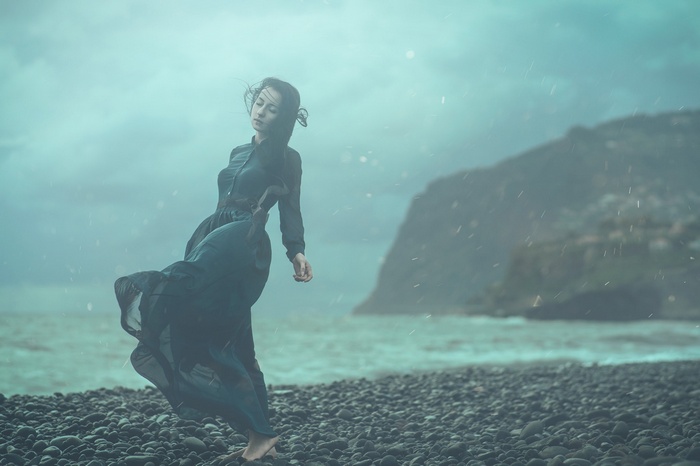 Woman in a dark dress on a rocky coast