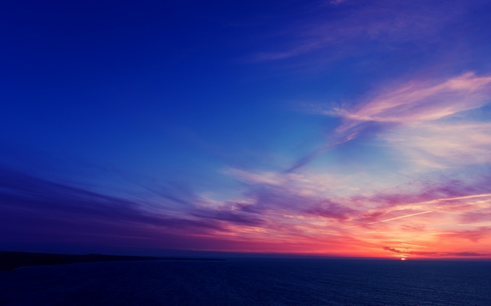 Sunset over the ocean with colorful clouds