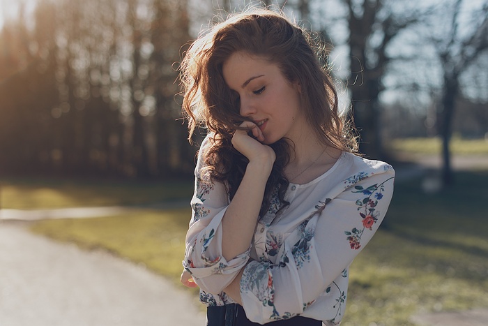 Woman with long wavy hair in a floral shirt outdoors