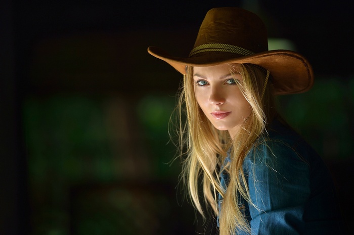 Woman wearing a cowboy hat and denim shirt