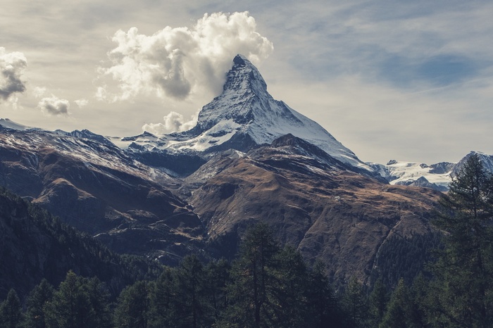 Matterhorn mountain peak with clouds and forest