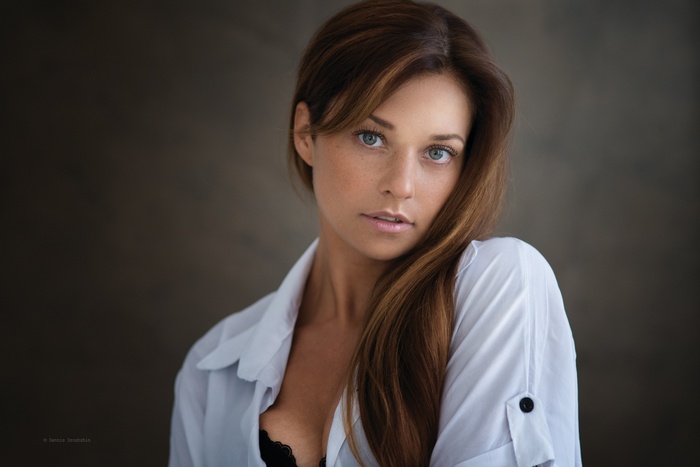 Woman with brown hair and blue eyes in white shirt
