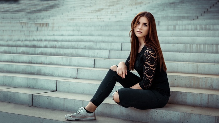 Woman with long hair sitting on stairs