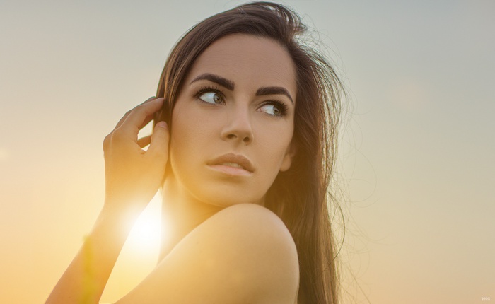 Woman looking away with sun flare