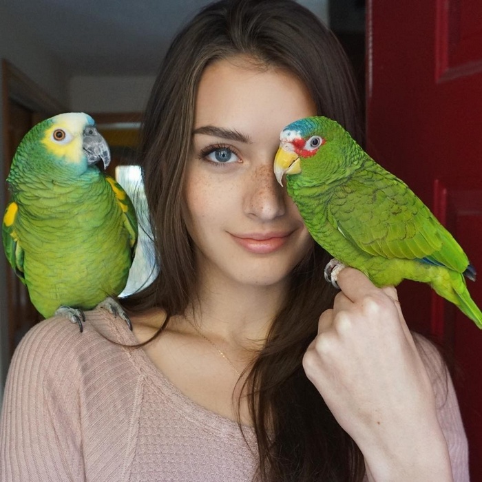 Jessica Clements with two parrots