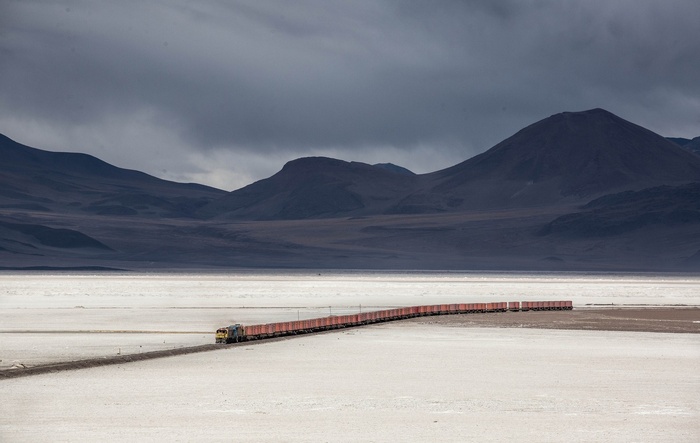 Train in a vast desert landscape with mountains